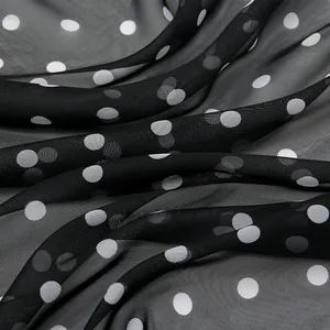 Detailed close-up of lightweight chiffon fabric featuring black and white polka dot pattern