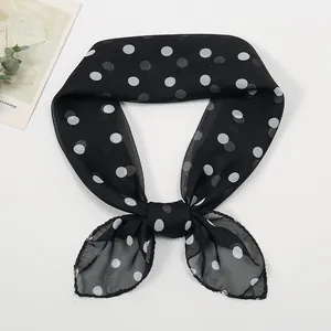Detailed close-up of lightweight chiffon neck scarf with classic black and white polka dots
