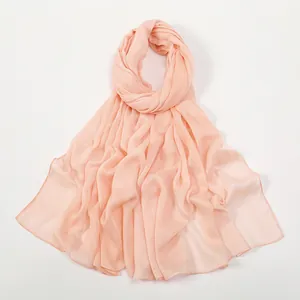 Detalle de la tela de bufanda rosa claro con textura microarrugada y caída suave y fluida