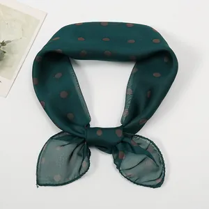 Close-up of lightweight dark green chiffon scarf with stylish brown polka dot pattern
