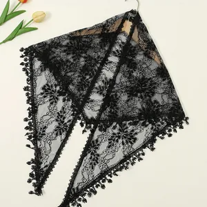 Detail of black floral lace triangle shawl with delicate fringe and embroidery