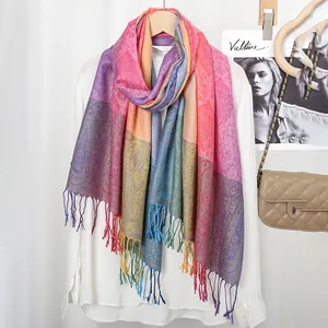 Dettaglio del ricamo paisley e delle frange arcobaleno su una sciarpa leggera pashmina