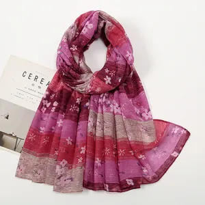 Detailaufnahme von lila gestreiftem Schal mit Blumenmuster und leichtem Chiffon