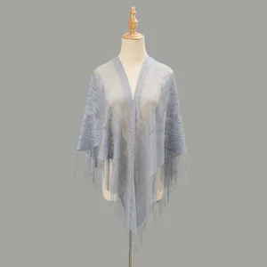 Dettaglio dello scialle in pizzo blu-grigio chiaro con ricami floreali e nappe lunghe