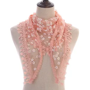 Detail of light pink floral lace triangle scarf with fringe edges on a mannequin stand
