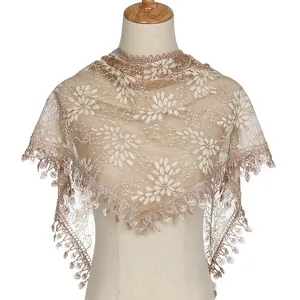 Detailed macro view of the floral lace embroidery and soft fringe edge of this triangle shawl