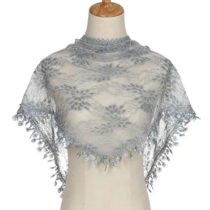 Close-up of floral lace shawl with delicate fringe tassels on a white background