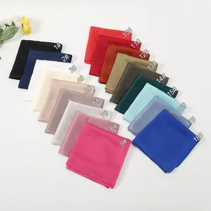 Flat lay of 18 colorful satin silk square scarves with smooth texture and clean edges