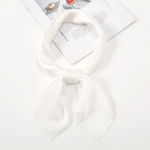 Detailed close-up of white satin silk scarf featuring a soft glossy texture and knotted style