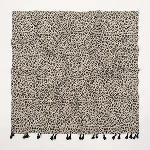 Détail d'une écharpe léopard en coton et lin avec des bordures à franges noires élégantes