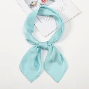Detailed view of a light blue satin square scarf with elegant knotting and smooth texture