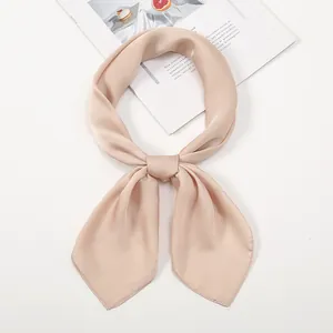 Detailed view of a champagne satin silk scarf tied in a knot on a white background