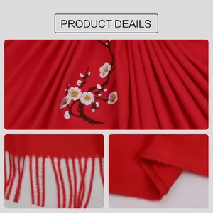 Detailed embroidery of white plum blossoms on a red cashmere-feel winter scarf with tassels
