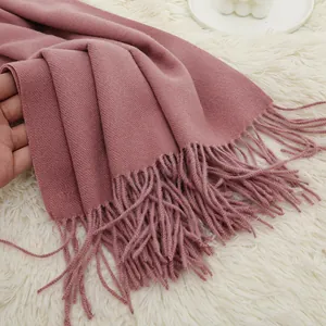 Detail showing soft cashmere-like twill weave fabric and tassels of a pink scarf