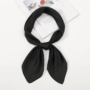 Detail of a black satin scarf tied in a neat bow knot with a smooth glossy texture
