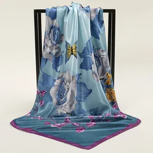 Detail of silk square scarf featuring blue rose and yellow butterfly floral patterns