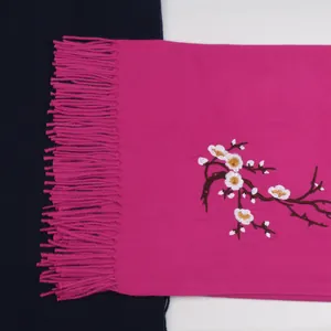Detailed view of rose red plum blossom embroidery and fringe on cashmere shawl