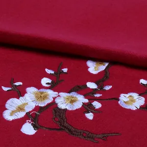 Macro shot of plum blossom embroidery on premium dark red cashmere-like thick shawl