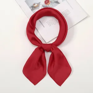 Detailed view of a bright red silk scarf tied in a bow on a stylish magazine background