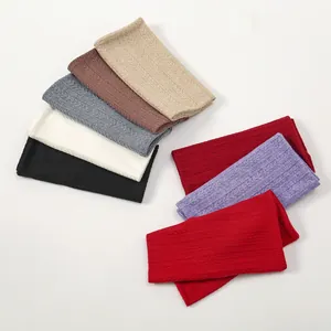 Detailed view of knitted winter neck warmers in various colors with ribbed texture and lining