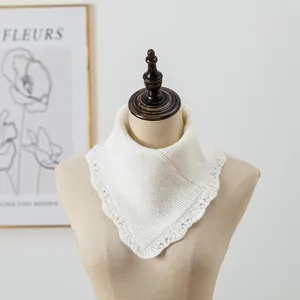 Détail d'un tour de cou en tricot ivoire avec bordure en dentelle festonnée délicate