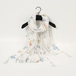 Detail of floral print on lightweight linen-feel scarf with delicate white fringe tassels