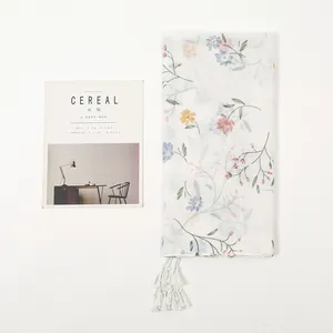 White linen-feel scarf with pastel floral prints and handmade tassel edges for women