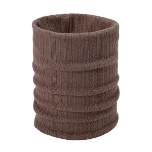 Detail of dark brown knitted neck gaiter featuring ribbed texture and warm cable knit design