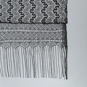 Detail of black ethnic lace scarf featuring wavy knit patterns and long fringed tassels