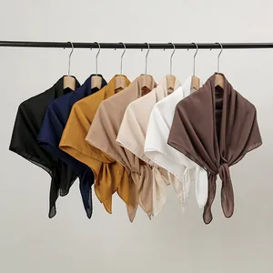Close-up of lightweight linen cotton scarves in seven solid colors on wooden hangers