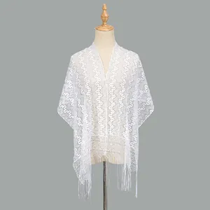 Detail of white lace shawl with geometric floral embroidery and long tassel hemline