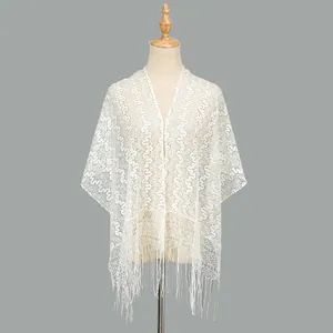 Detail of white lace cardigan with wave patterns and long tassel fringe trim