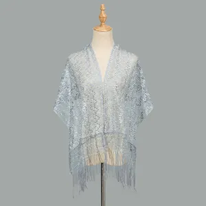 Close-up of light blue lace shawl featuring intricate hollow-out floral patterns and long tassels