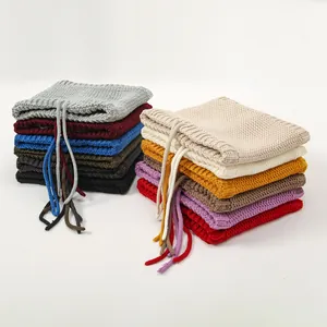 Detailed close-up of colorful knitted neck warmers with adjustable drawstrings