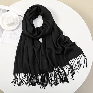 Detailed view of black cashmere feel scarf with soft fringe edges and elegant texture