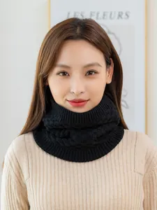 Close-up of black cable knit neck warmer with thick ribbed texture and high collar design