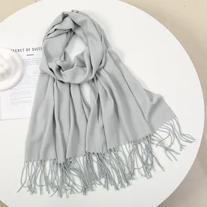 Close-up of light gray cashmere-feel scarf with soft fringe edges and woven texture