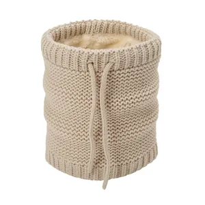 Detailed view of beige knit neck warmer with thick faux fur lining and drawstring
