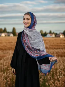 Detail of bohemian geometric scarf with blue and pink tassels against field background