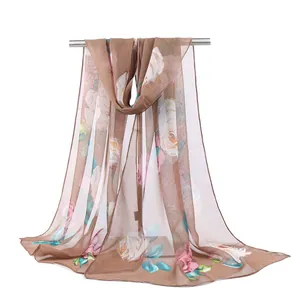 Detail of floral chiffon scarf with rose print hanging on a metal rack