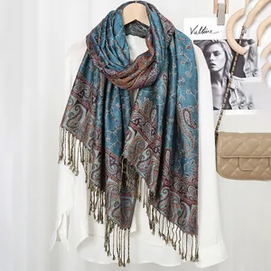 Detailed view of paisley print scarf with fringe tassels on white shirt