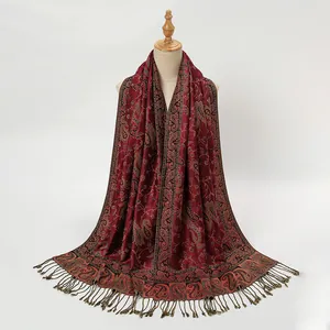 Detail showing burgundy paisley pattern scarf with elegant fringe tassels on a mannequin