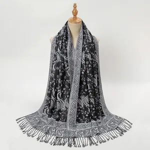 Detail of elegant black and silver paisley embroidered shawl with fine fringe tassels