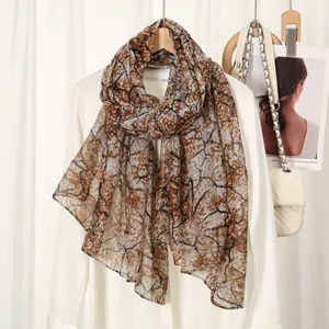 Lightweight voile scarf with vintage branch pattern print on casual white shirt