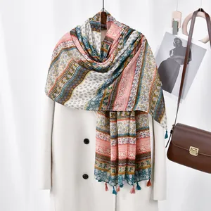 Ethnic floral print bali yarn scarf with colorful tassels hanging on white coat