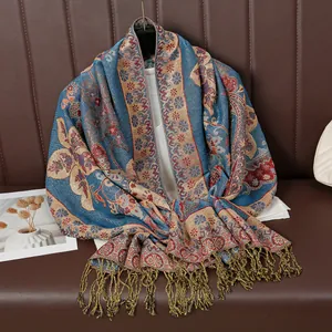 Detail eines dunkelblauen Vintage-Schals mit roter Stickerei und goldenen Quasten
