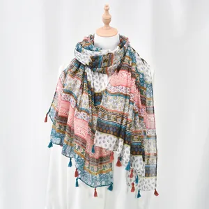 Detailed view of bohemian floral print scarf with ethnic fringe tassels on white mannequin