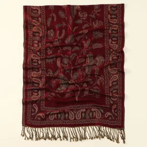 Dettaglio del ricamo paisley bordeaux e frange testurizzate su scialle tessuto vintage