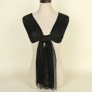 Detail of black shimmering shawl with metallic threads and long fringe trim design