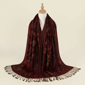 Dettaglio del motivo paisley rosso scuro e delle frange fatte a mano sullo scialle